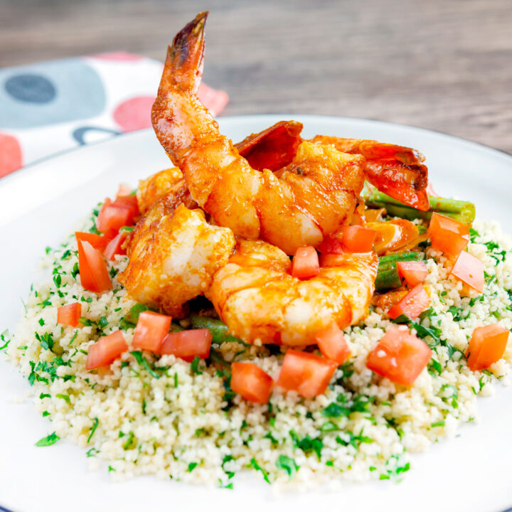 Moroccan influenced garlic harissa prawns served with herby couscous, tomatoes and green beans.