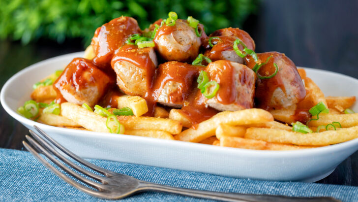 Homemade German currywurst with curry ketchup and French fries.