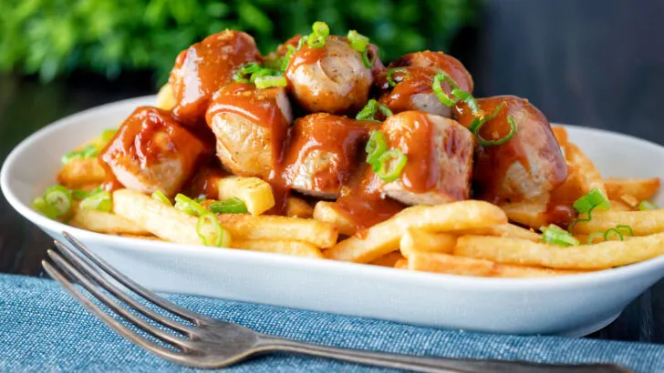 Homemade German currywurst with curry ketchup and French fries.