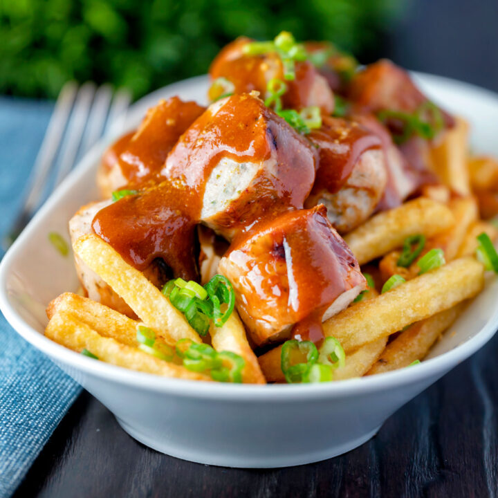 Homemade German currywurst with curry ketchup and French fries.