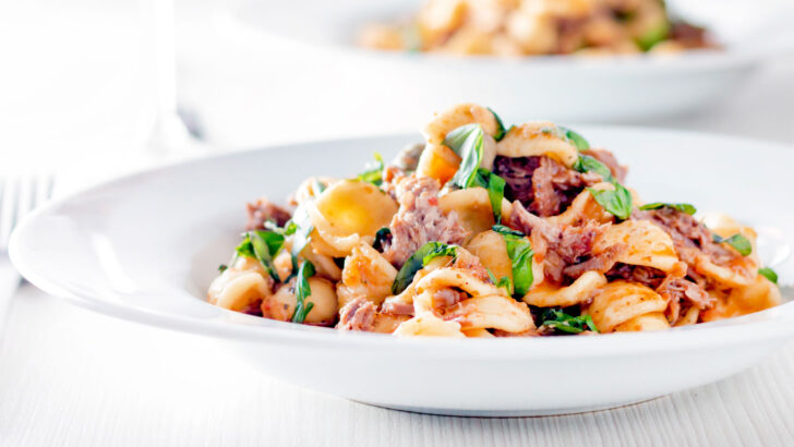 Instant Pot or pressure cooker pork ragu with orecchiette pasta served in a white bowl.