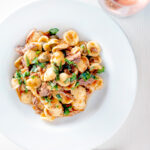 Overhead Instant Pot pork ragu with orecchiette pasta served in a white bowl.