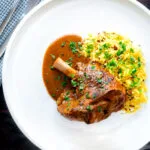 Overhead lamb shank curry or nalli gosht served with pilau rice.