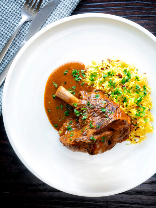 Overhead lamb shank curry or nalli gosht served with pilau rice.