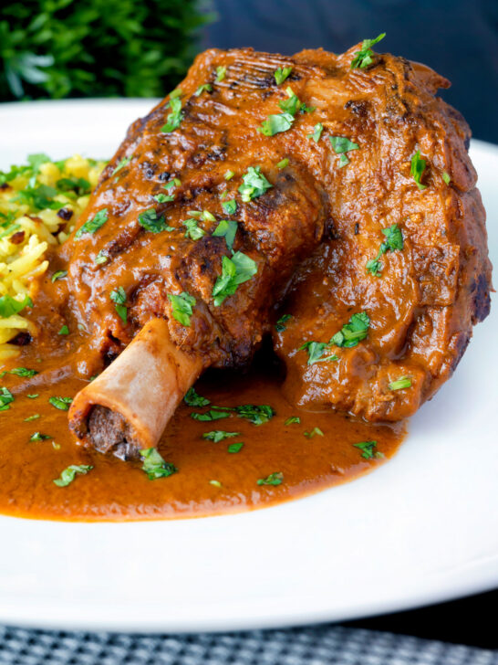 Close up lamb shank curry or nalli gosht served with pilau rice.