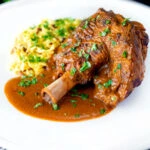 Lamb shank curry or nalli gosht served with pilau rice.
