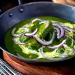 Palak chicken or murgh curry with red onions and cream featuring a title overlay.