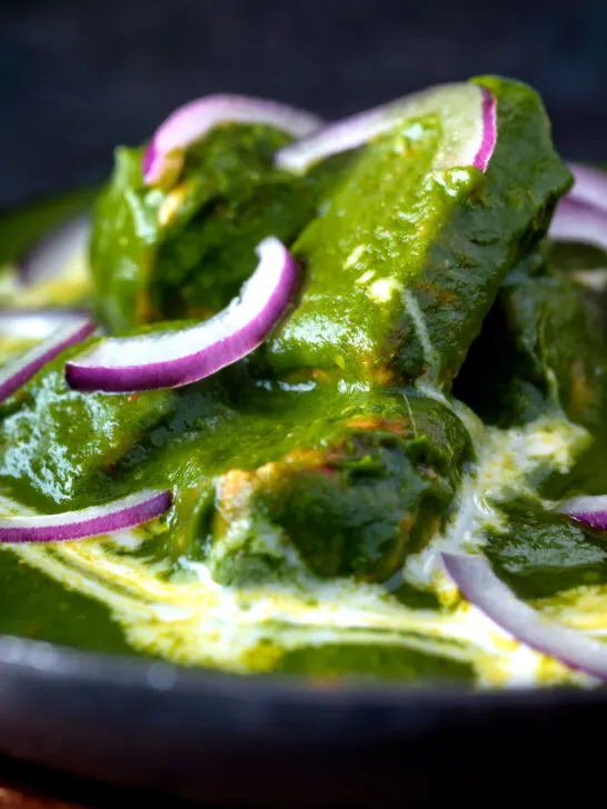 Close up palak chicken or murgh curry with red onions and cream.