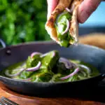 Palak chicken or murgh curry being eaten with naan bread!