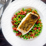Overhead pan fried cod loin with chorizo, peas and leeks.
