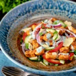 Paneer tikka salad with cucumber, tomato, onion and yoghurt raita dressing.