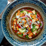 Overhead paneer tikka salad with yoghurt raita dressing featuring a title overlay.