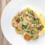 Overhead pork tenderloin with prunes in a brandy cream sauce.