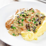 Pork fillet with prunes in a brandy cream sauce featuring a title overlay.