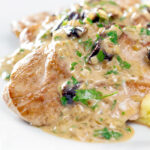 Close up pork tenderloin with prunes in a brandy cream sauce.