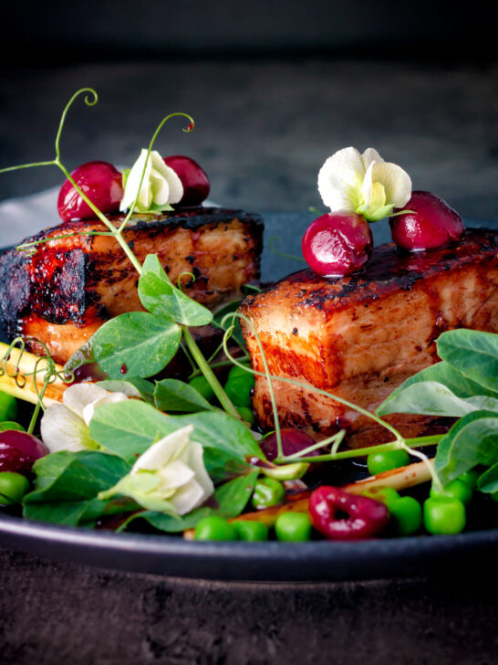 Twice cooked pressed crispy pork belly with port cherries and peas.