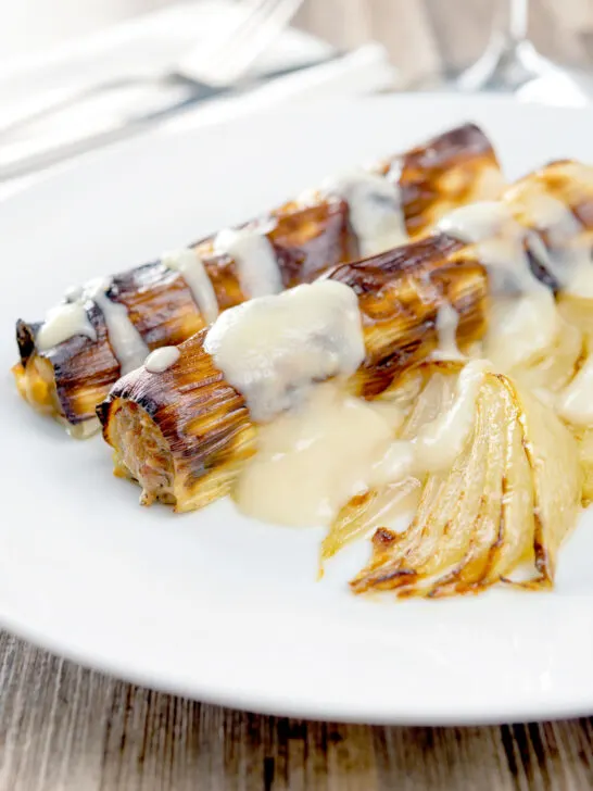 Homemade skinless sausages wrapped in charred leeks with pear and cider sauce.