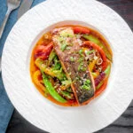 Overhead crispy skinned sweet and sour salmon fillets with vegetables.