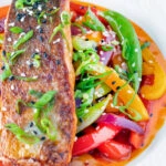 Crispy skinned sweet and sour salmon fillets with vegetables.