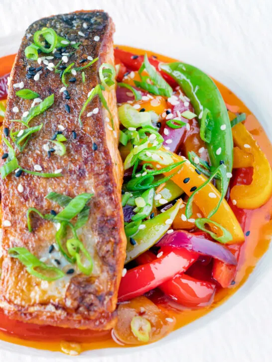 Crispy skinned sweet and sour salmon fillets with vegetables.