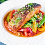 Crispy skinned sweet and sour salmon fillets with peppers and sugar snap peas.