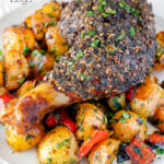 Close up baked zaatar chicken legs served with spicy Lebanese potatoes featuring a title overlay.