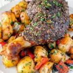 Close up baked zaatar chicken legs served with spicy Lebanese potatoes featuring a title overlay.