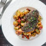 Overhead baked zaatar chicken legs served with spicy Lebanese potatoes featuring a title overlay.