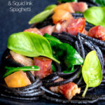 Close up bacon pasta with squid ink spaghetti, spinach and tomatoes featuring a title overlay.