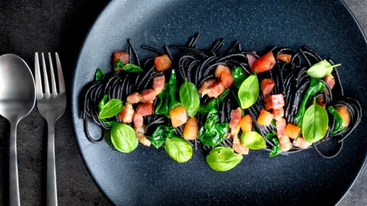 Bacon pasta with squid ink spaghetti, spinach, tomatoes and fresh basil.