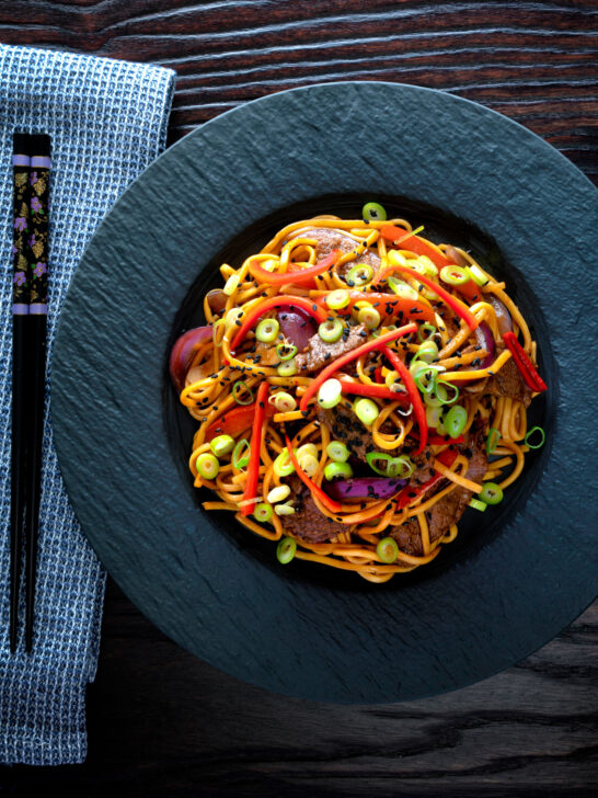 Overhead beef noodle stir fry with sweet chilli sauce and red peppers.