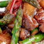 Close up Korean pork belly with a gochujang glaze and asparagus.