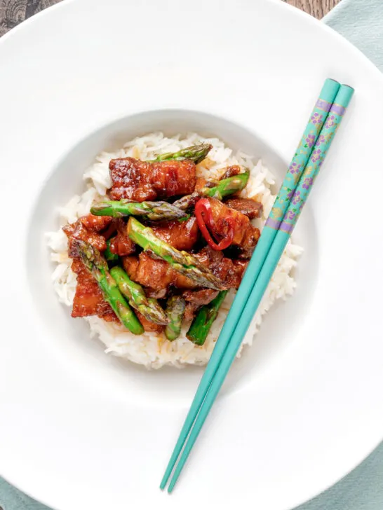 Overhead Korean pork belly with a gochujang glaze and asparagus.