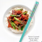 Overhead Korean pork belly with a gochujang glaze and asparagus featuring a title overlay.
