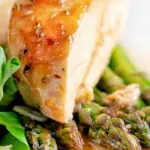 Close up orange marmalade chicken breast served with asparagus.