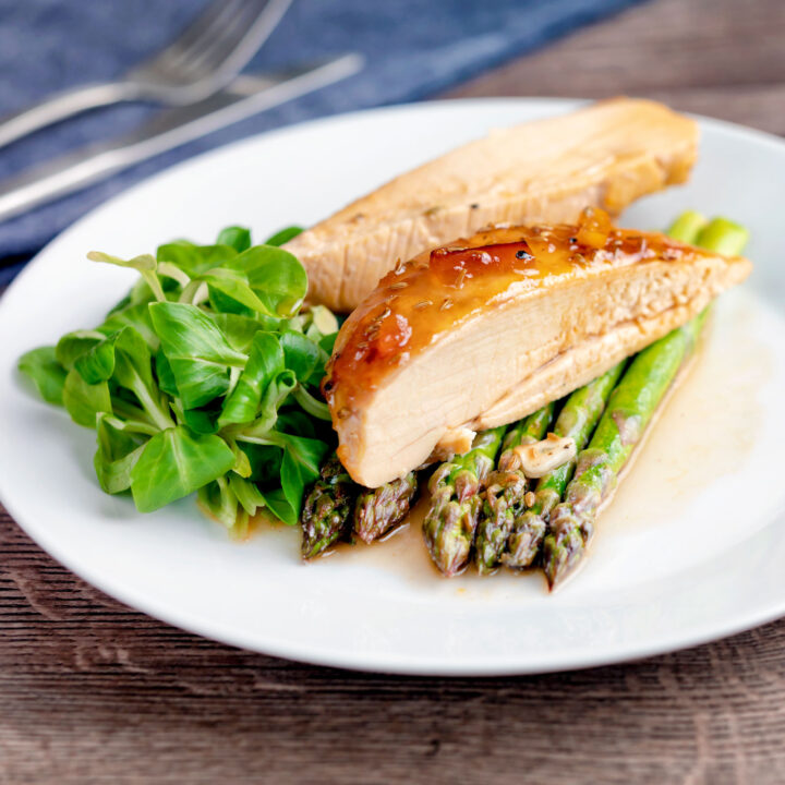 Sticky glazed orange marmalade chicken breast served with asparagus.