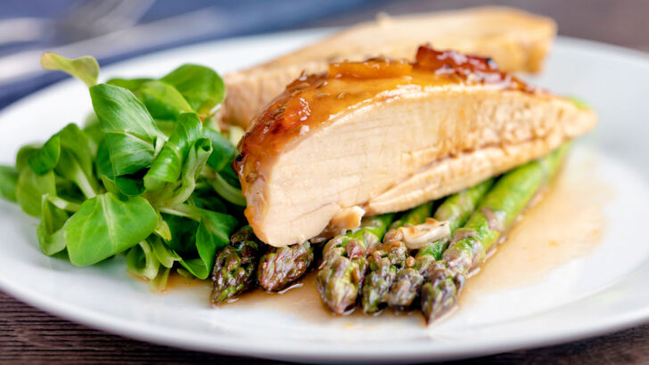 Sticky glazed orange marmalade chicken breast served with asparagus.