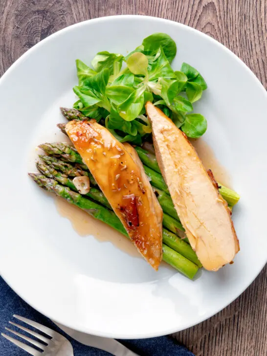 Overhead orange marmalade chicken breast served with asparagus.