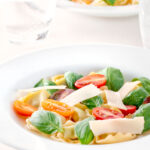Tomato consomme or brodo with tortellini and cherry tomatoes.