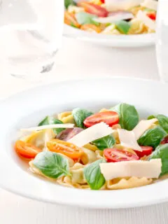 Tomato consomme or brodo with tortellini and cherry tomatoes.