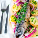 Baked whole mackerel with salad potatoes, red onions and chives.