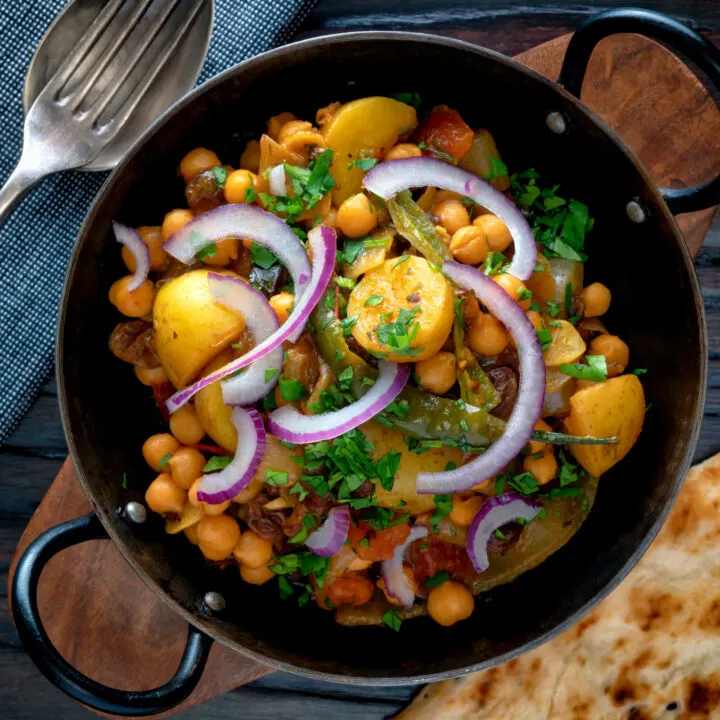Chana aloo, an Indian chickpea and potato curry served with red onion and fresh coriander.