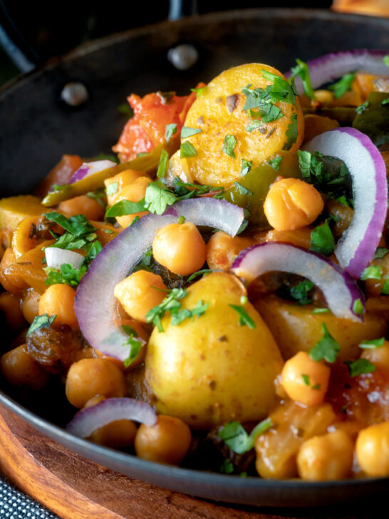 Indian chana aloo, a chickpea and potato curry served with red onion.