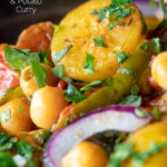 Close up chana aloo, an Indian chickpea and potato curry served with red onion featuring a title overlay.