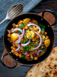 Overhead chana aloo, an Indian chickpea and potato curry served with red onion.