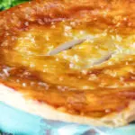 Close up puff pastry topped individual creamy chicken and leek pie.