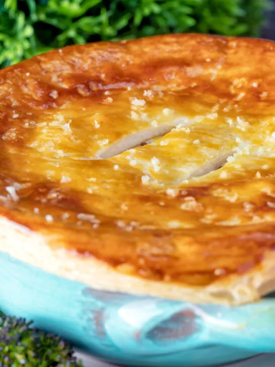 Close up puff pastry topped individual creamy chicken and leek pie.