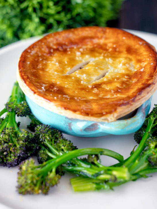 Puff pastry topped individual creamy chicken and leek pie served with broccoli.