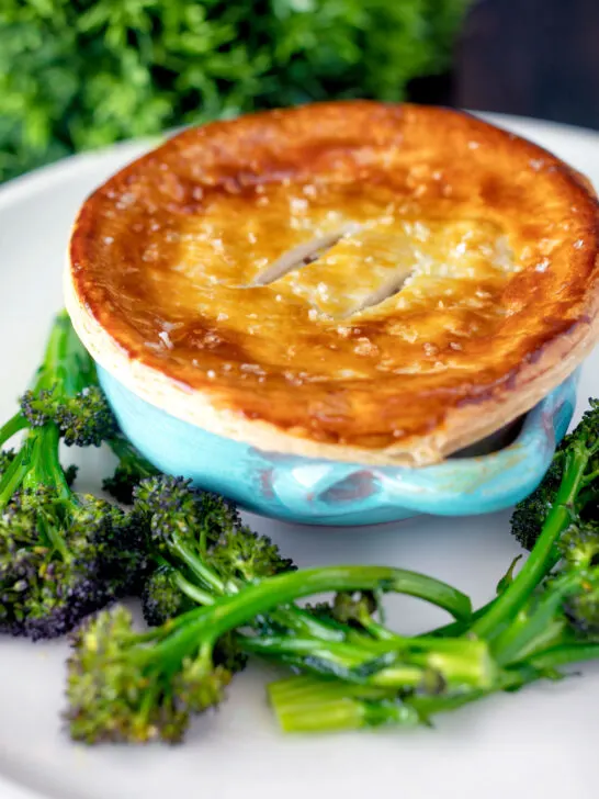 Puff pastry topped individual creamy chicken and leek pie served with broccoli.