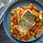 Overhead crispy skinned masala fish fillet (coley) served with masala chips.